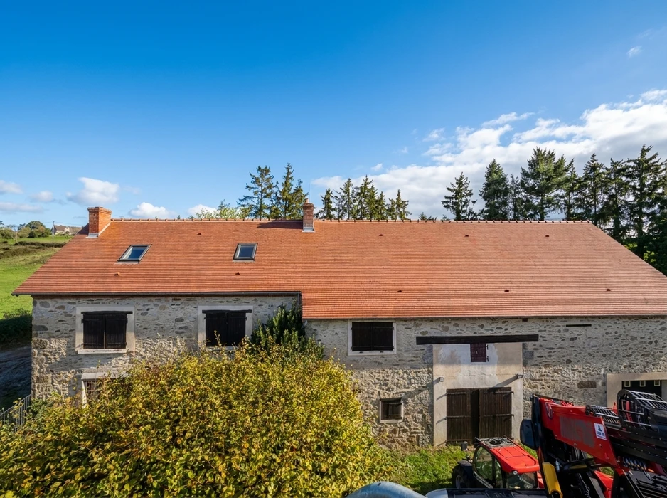 Ferme en pierre de granit avec toiture neuve en tuiles plates terre cuite, vue aérienne extérieure