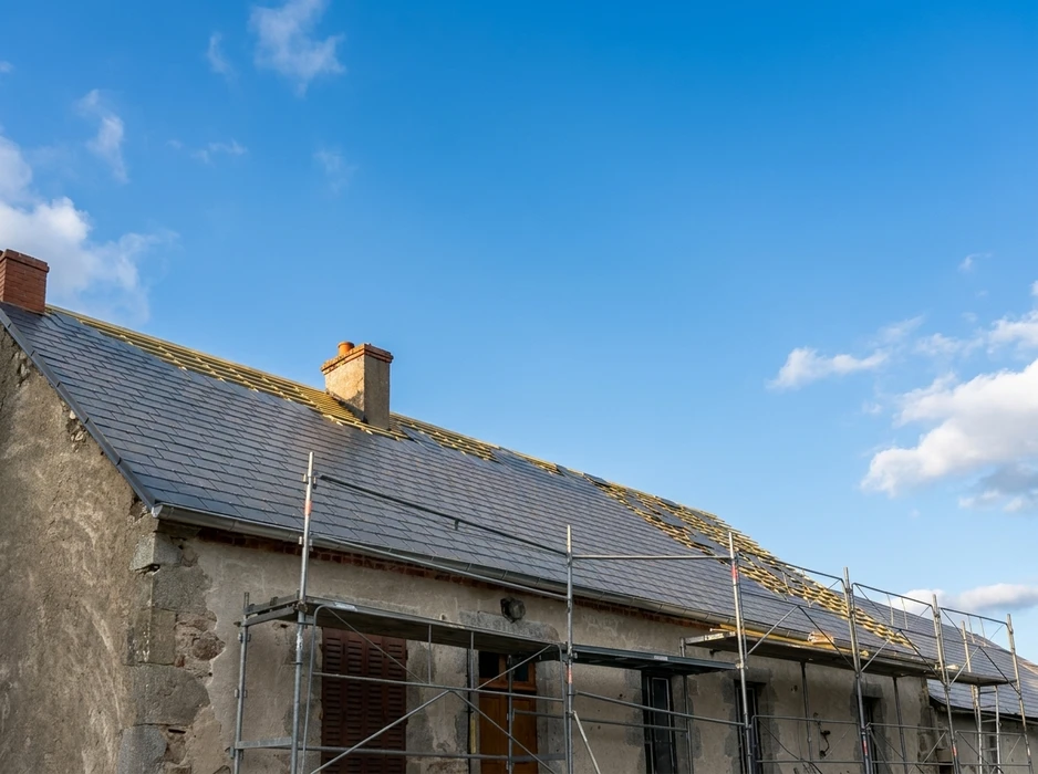 Rénovation de toiture en ardoises naturelles sur bâtiment ancien, avec échafaudage tubulaire